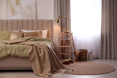 Modern oda içinde zeytin yeşili çarşafları olan rahat bir yatak.