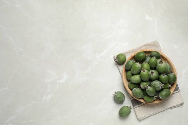 Açık gri mermer masa üzerinde taze yeşil feijoa meyveleri ile düz kompozisyon, metin için boşluk