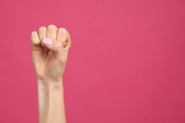 Pembe arka planda yumruğu kız güç sembolü olarak gösteren kadının yakın görüntüsü, mesaj için boşluk. 8 Mart konsepti
