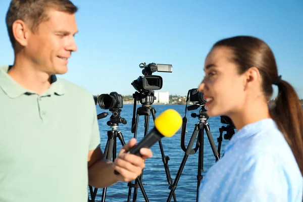 Journalist Intervjuar Ung Kvinna Nära Floden Fokus Videokameror — Stockfoto