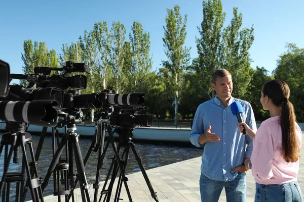 Ung Journalist Intervjuar Man Nära Floden Solig Dag — Stockfoto