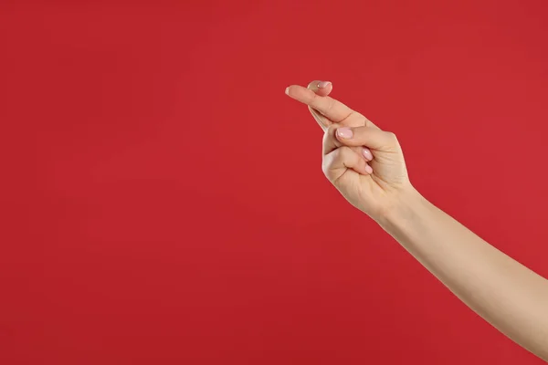 女人手指头交叉在红色的背景上 与文字的空间紧密相连 祝好运迷信 — 图库照片