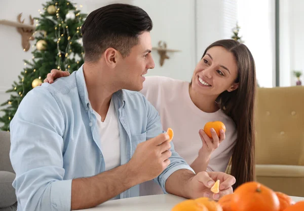 Glückliches Paar Mit Mandarinen Weihnachtlich Dekorierten Zimmer — Stockfoto