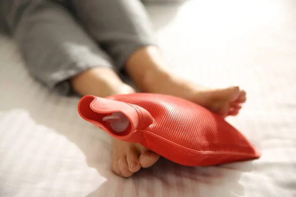 Kvinna Värmande Fötter Med Varmvatten Flaska Sängen Närbild — Stockfoto