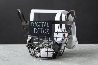 Farklı aygıtlara ve sözcüklere sahip çöp kutusu Açık gri mermer masa üzerinde DIGITAL DETOX