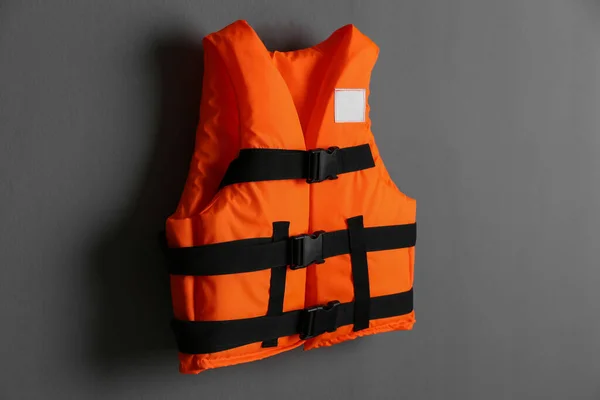 グレーの背景にオレンジのライフジャケット 個人用浮体装置 — ストック写真