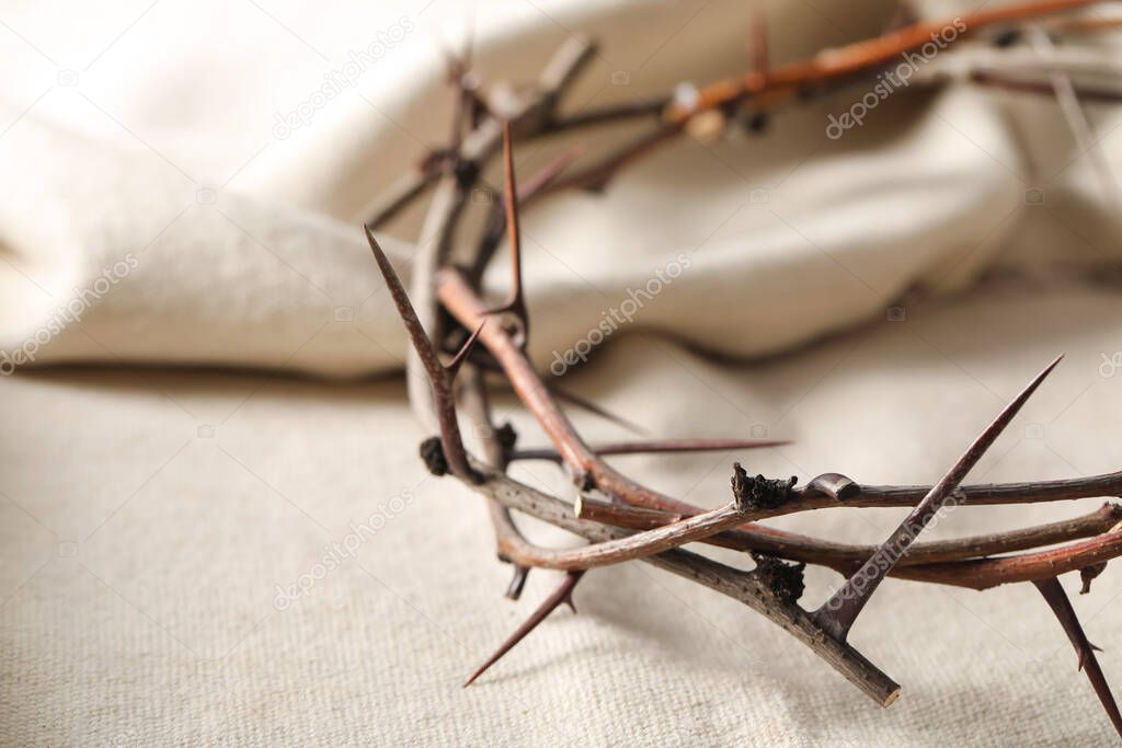 Crown of thorns on white fabric, closeup. Easter attribute