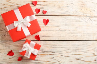Güzel hediye kutuları ve beyaz ahşap masa üzerinde kağıt kalpler, düzlük ve metin için boşluk. Sevgililer Günü kutlaması