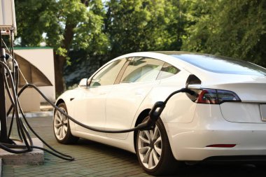Dışarıdaki istasyondan modern elektrikli araba şarj ediliyor.