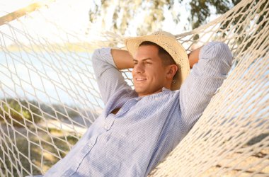 Sahilde hamakta dinlenen bir adam. Yaz tatili