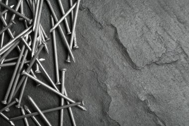 Gri arka planda bir sürü metal çivi var. Metin için boşluk