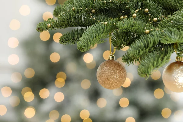 Bolas Natal Douradas Penduradas Abeto Contra Luzes Festivas Desfocadas — Fotografia de Stock