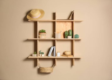 Bej duvarda farklı dekoratif elementlere sahip ahşap raflar