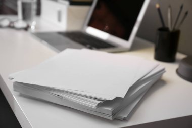 Ofisteki beyaz masada boş kağıt yığını, yakın plan. Metin için boşluk