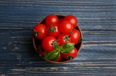 Taze vişneli domates ve fesleğen mavi ahşap masa, üst manzara