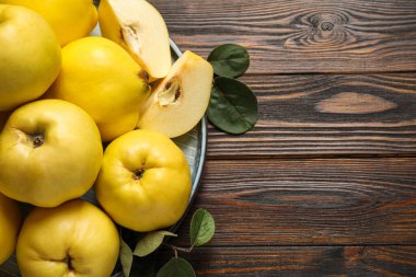 Tahta masa üzerinde yaprakları olan taze, organik ayva. Metin için boşluk