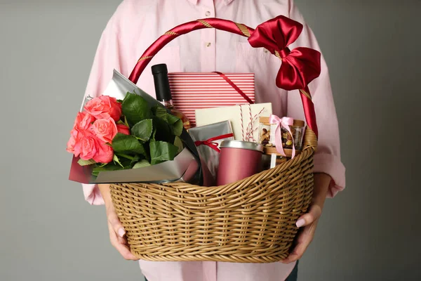 Woman Holding Wicker Basket Full Presents Grey Background Closeup — Stock Photo, Image