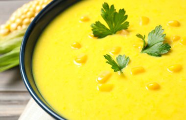 Lezzetli kremalı mısır çorbası ve maydanozlu kase, yakın plan.