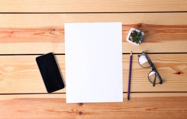 Düz kompozisyon ve tahta zemin üzerinde boş kağıt levha. Metin için boşluk