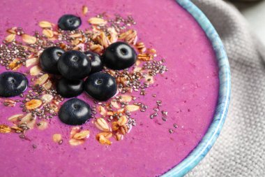 Tatlı kasesinde granola ve chia tohumlu lezzetli acai smoothie, yakın plan.