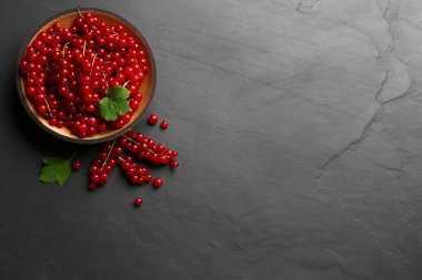 Siyah tahta üzerinde nefis kırmızı üzümler, düz bir masa. Metin için boşluk