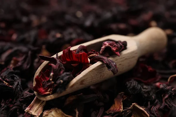 Wooden scoop with dry hibiscus tea, closeup