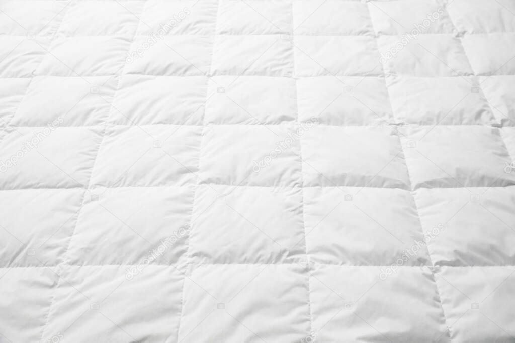 Soft quilted blanket as background, closeup view