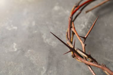 Gri arkaplanda dikenli bir taç, yazı için yere yakın çekim. Paskalya niteliği