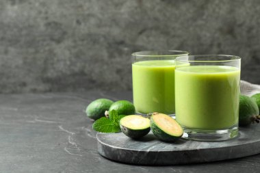 Taze feijoa smoothie ve gri masada taze meyveler, metin için yer