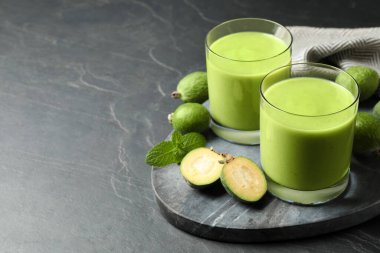Taze feijoa smoothie ve gri masada taze meyveler, metin için yer