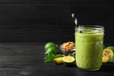 Taze feijoa smoothie ve siyah ahşap masada taze malzemeler. Metin için boşluk