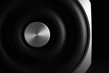 Modern subwoofer siyah arka planda, yakın plan. Güçlü ses hoparlörü