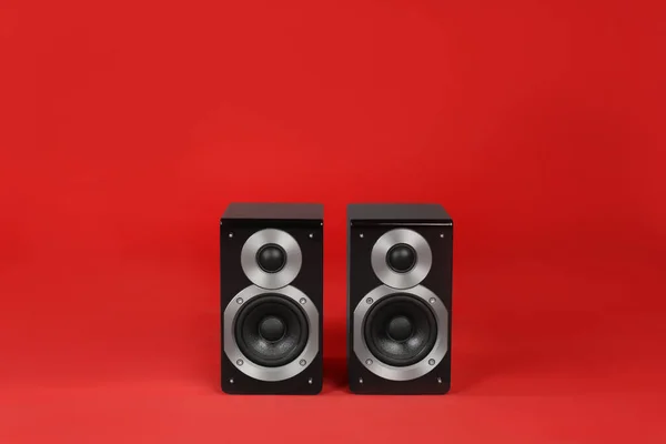 Modern powerful audio speakers on red background