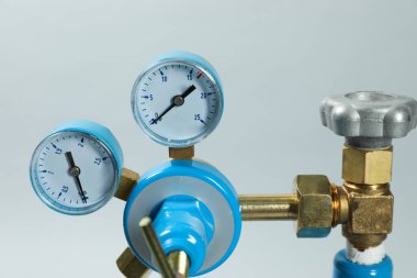 Açık gri arka planda tıbbi oksijen tankının basınç göstergesi, yakın plan