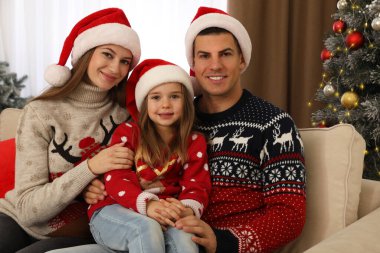 Noel Baba şapkalı mutlu aile evde Noel ağacının yanında