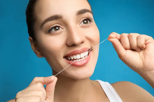 Wanita Muda Flossing Giginya Pada Latar Belakang Biru Dokter Gigi — Stok Foto