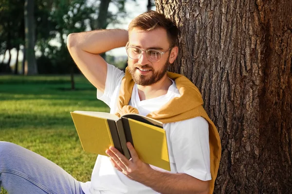 Junger Mann Liest Buch Neben Baum Park — Stockfoto