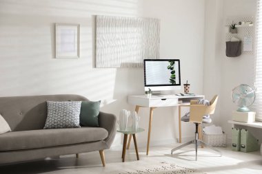 Modern bilgisayarlı, masa başında rahat bir ofis sandalyesi.