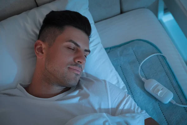 Mężczyzna Śpiący Elektrycznym Podkładce Grzewczej Łóżku Nocy Powyżej Widoku — Zdjęcie stockowe