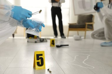 Olay yerinde çalışan müfettişler dağınık odada, yakın plan.