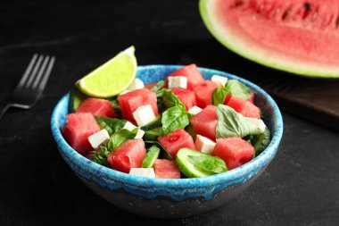 Siyah masada servis edilen karpuzlu lezzetli salata.