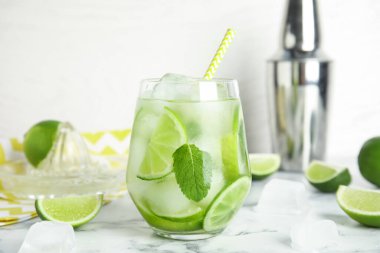 Lezzetli mojito ve beyaz mermer masadaki malzemeler.