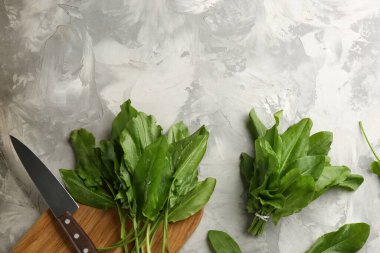 Gri arka planda at gülü ve bıçaklı kesme tahtası, düz. Metin için boşluk