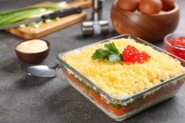 Geleneksel Rus salatası Mimosa gri masada servis edilir.