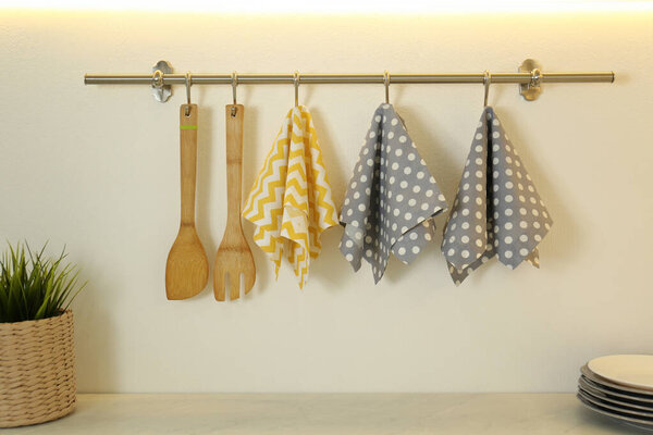 Different kitchen towels hanging on hook rack indoors
