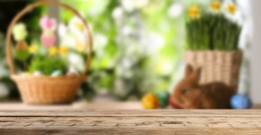 Boş ahşap yüzey ve arkasında renkli Paskalya yumurtaları olan hasır sepetler. Pankart tasarımı