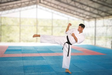 Profesyonel koç spor salonunda karate hareketleri gösteriyor.