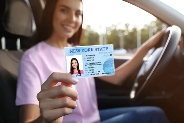 Χαρούμενη Νεαρή Γυναίκα Που Κρατάει Δίπλωμα Ενώ Κάθεται Στο Αυτοκίνητο — Φωτογραφία Αρχείου