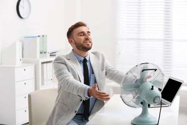Mann Genießt Luftstrom Aus Ventilator Arbeitsplatz — Stockfoto