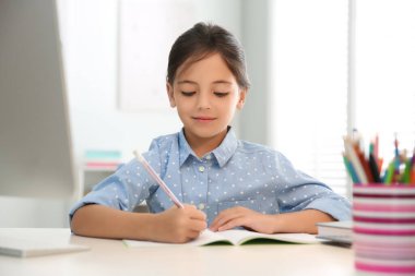 Uzaktan öğrenme, evde çalışma. Covid-19 salgınından dolayı karantina ve tecrit sırasında online okul dersi alan bir kız.